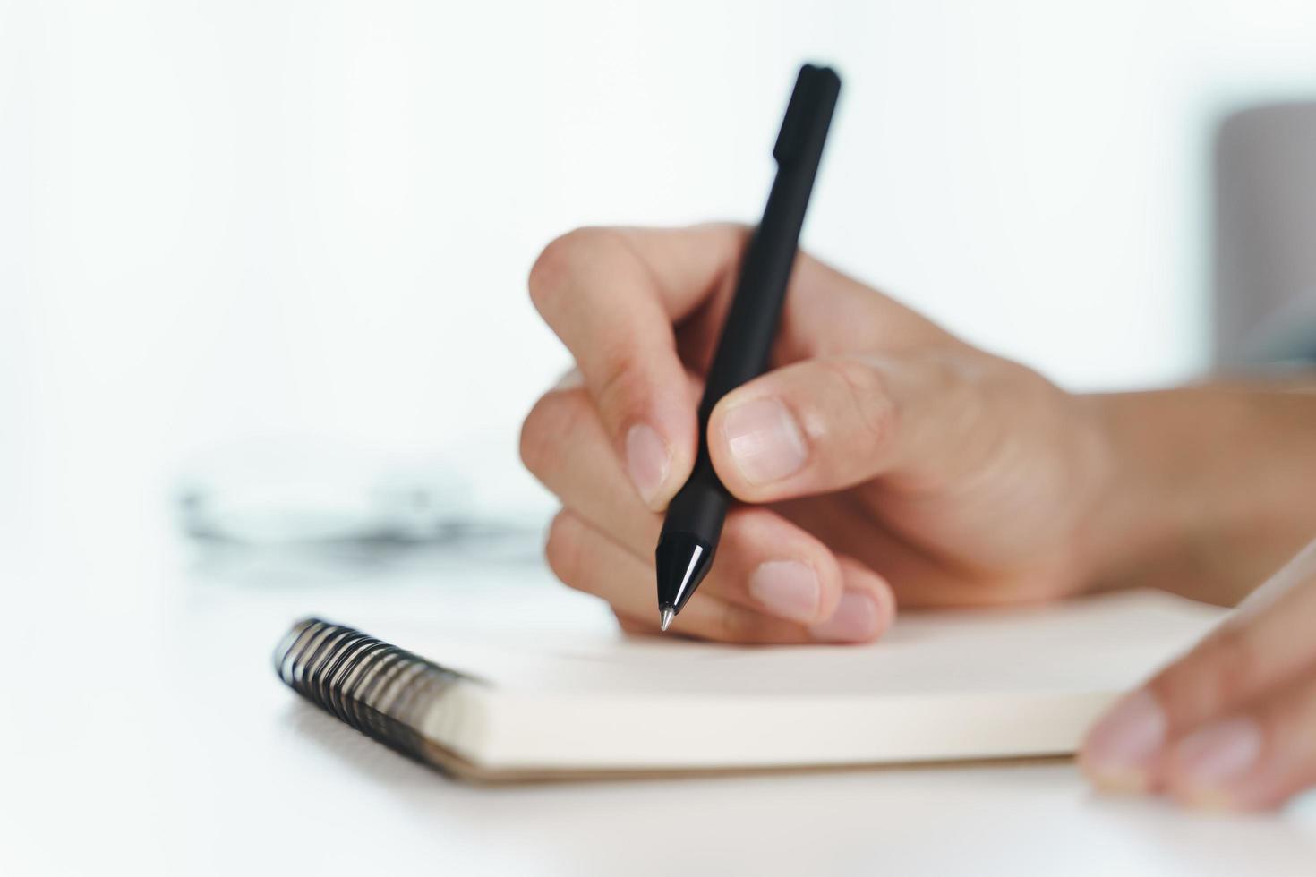 Close-up of hands resting on an open notebook, ready to write